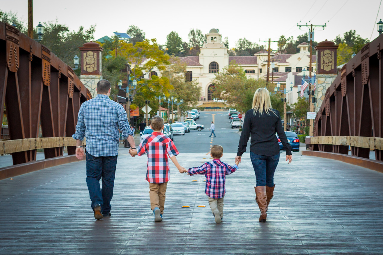Family walking hand in hand across a bridge